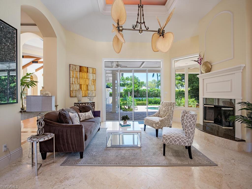 194 4th Avenue North Naples, FL 34102 - Photo 14 of 37 a living room with furniture a fireplace and a chandelier