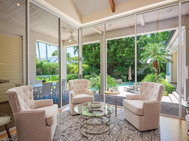 a living room with furniture and a large window with garden view