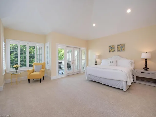 a spacious bedroom with a bed and large window