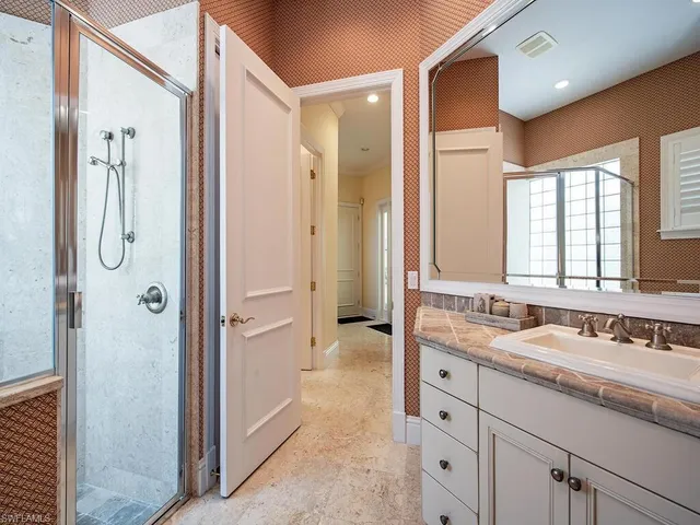 a spacious bathroom with a double sink shower and a mirror
