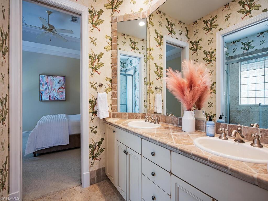 194 4th Avenue North Naples, FL 34102 - Photo 33 of 37 a en suite bathroom with a double vanity sink a mirror and a shower