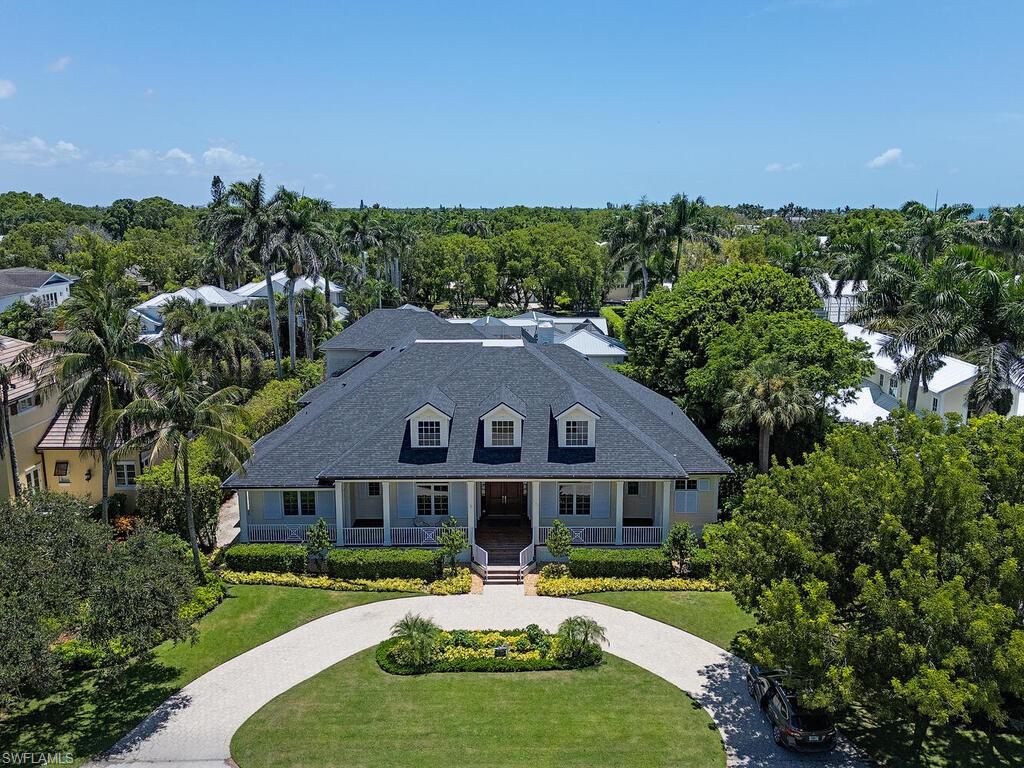 194 4th Avenue North Naples, FL 34102 - Photo 5 of 37 a front view of a house with a garden