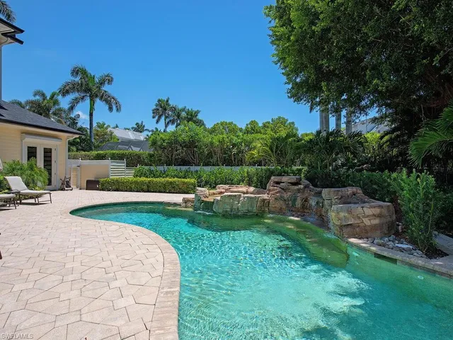 a view of backyard with swimming pool and seating space