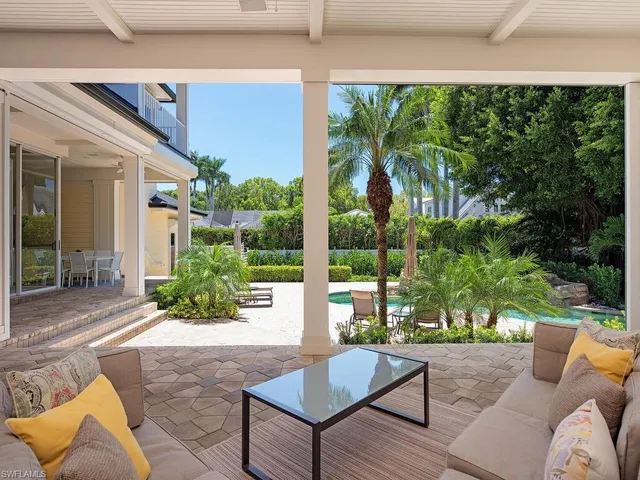 a view of a patio with table and chairs potted plants and large tree