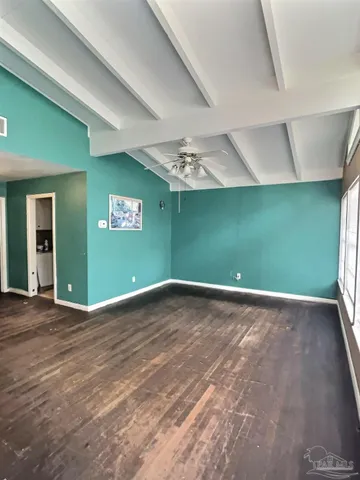a view of empty room with window and ceiling fan