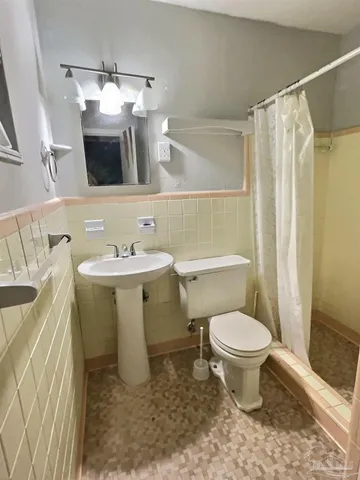 a bathroom with a sink toilet mirror and vanity