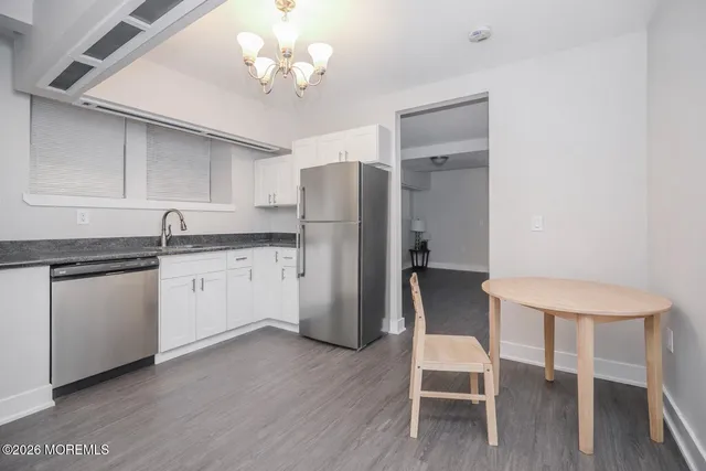 a kitchen with a table chairs refrigerator and cabinets
