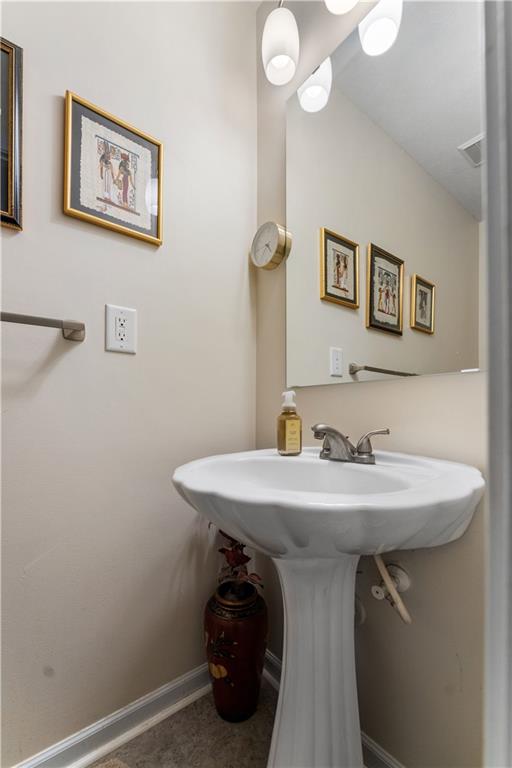 2008 Arbor Ridge Court Cheswick, PA 15024 - Photo 11 of 26 The first floor bathroom features a pedestal sink, vinyl floor, beautiful lighting and mirror.