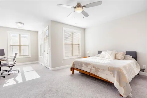 a bedroom with a bed tv and a window