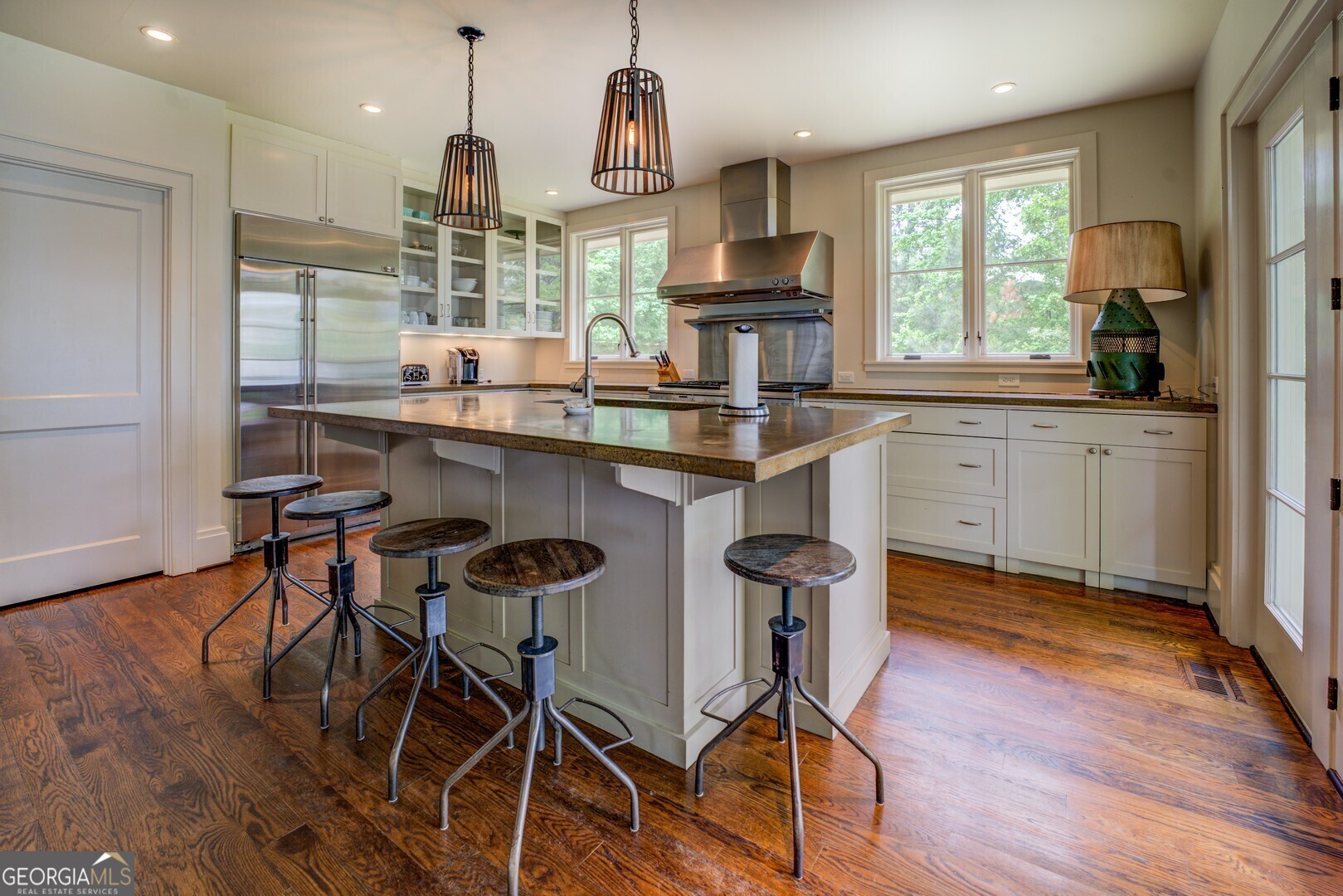 172 Tater Hill Road Jackson, GA 30233 - Photo 30 of 84 a kitchen with kitchen island granite countertop wooden floors and white cabinets