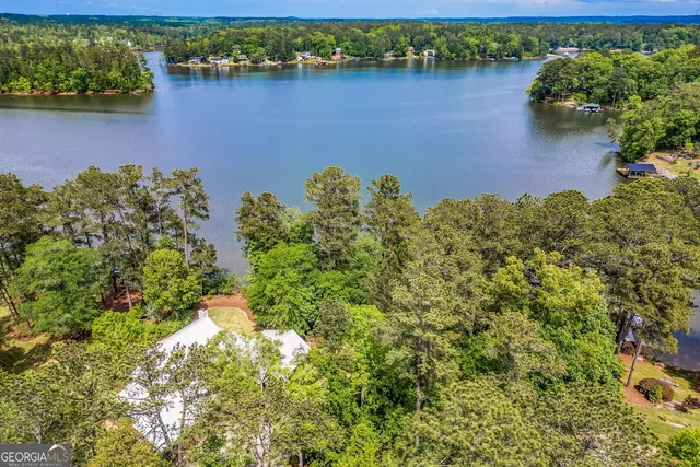 a living room with furniture a chandelier and a dining table with wooden floor