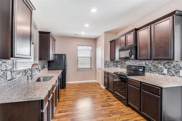 a kitchen with stainless steel appliances granite countertop a sink and cabinets