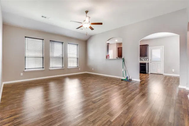 a view of empty room with wooden floor and window