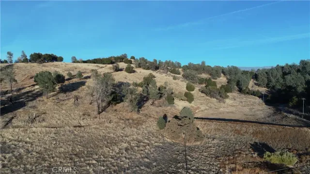 a view of a dry yard with mountains in the background