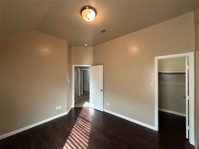an empty room with wooden floor and closet