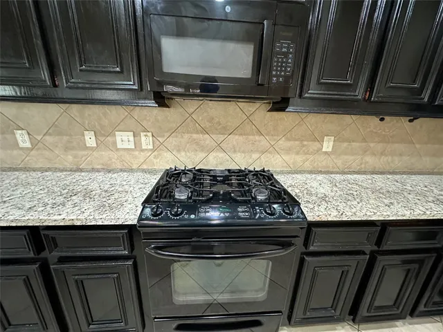 a stove top oven sitting inside of a kitchen