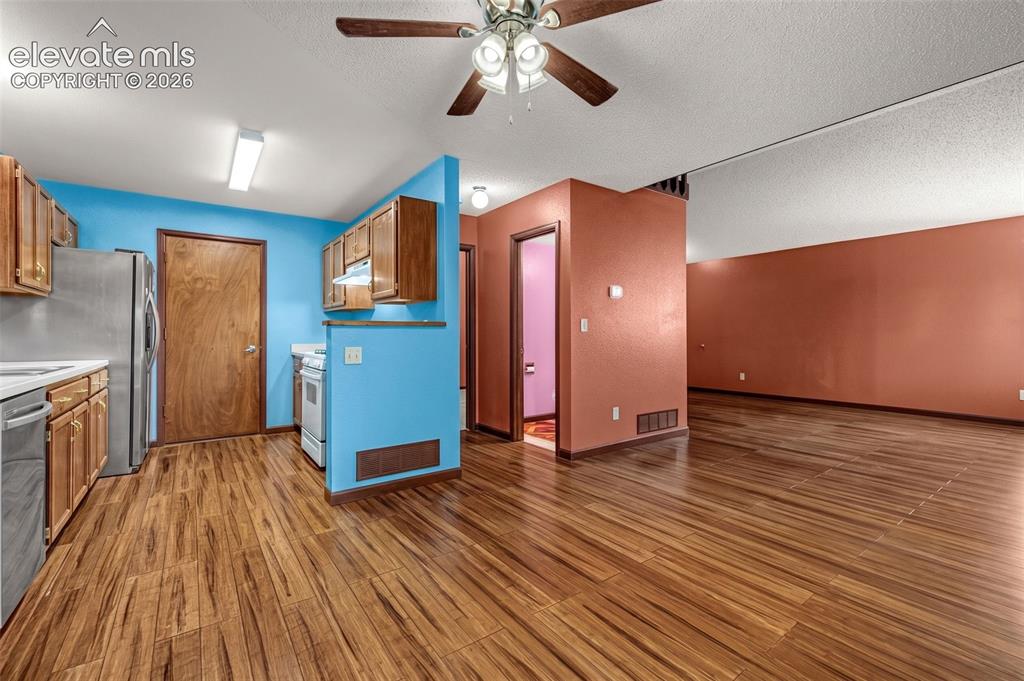 613 Wheat Field Road Fountain, CO 80817 - Photo 7 of 32 a view of a kitchen with wooden floor and a ceiling fan