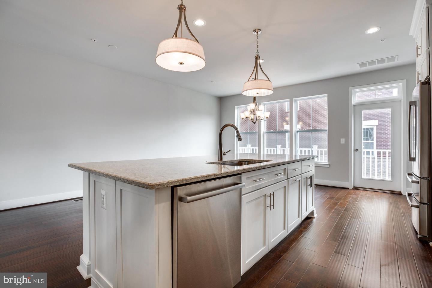 1979 Roland Clarke Place Reston, VA 20191 - Photo 11 of 52 a kitchen with stainless steel appliances granite countertop a sink a stove and wooden floors