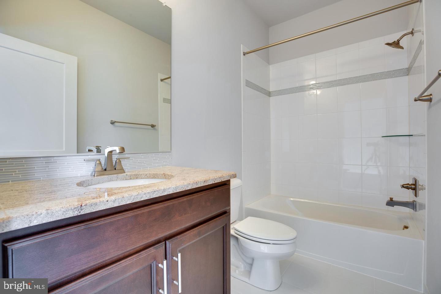 1979 Roland Clarke Place Reston, VA 20191 - Photo 37 of 52 a bathroom with a granite countertop sink toilet and shower