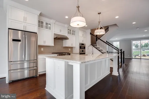 a kitchen with stainless steel appliances a refrigerator a sink and a stove