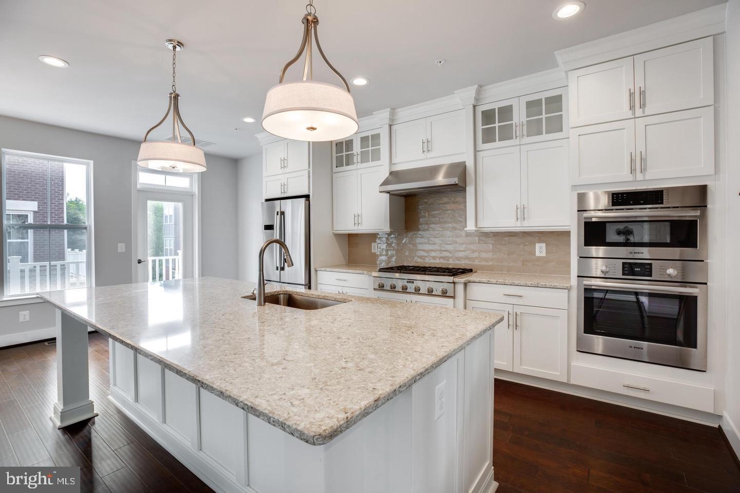 1979 Roland Clarke Place Reston, VA 20191 - Photo 8 of 52 a kitchen with kitchen island granite countertop a stove a sink a center island and cabinets