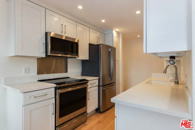 a kitchen with stainless steel appliances a refrigerator stove and microwave