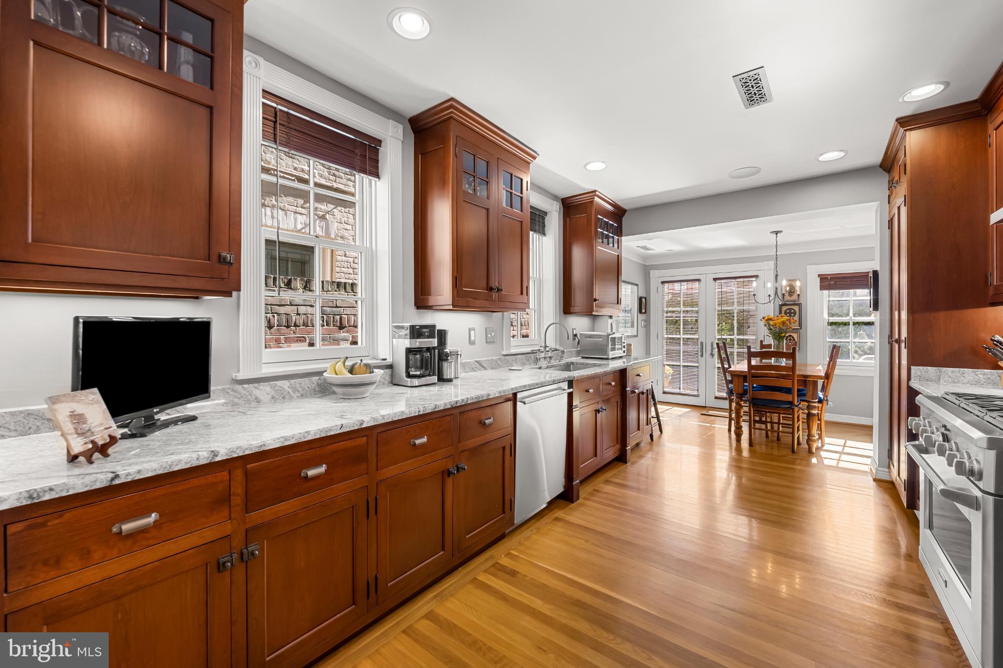 407 Warren Avenue Baltimore, MD 21230 - Photo 28 of 85 a open kitchen with stainless steel appliances granite countertop a refrigerator a sink dishwasher a stove and a dining table with wooden floor