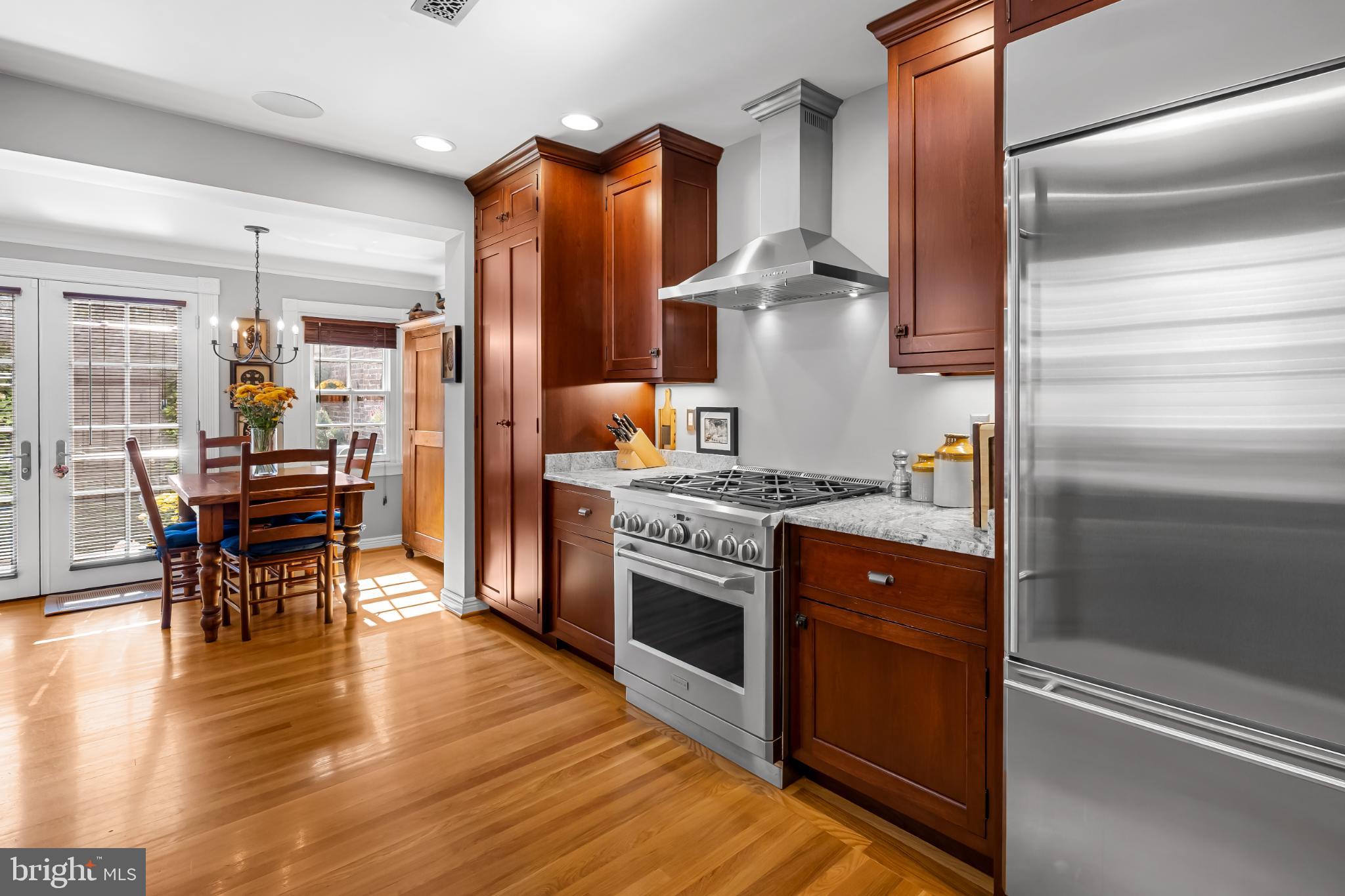 407 Warren Avenue Baltimore, MD 21230 - Photo 29 of 85 a kitchen with stainless steel appliances granite countertop a refrigerator a stove and a dining table with wooden floor