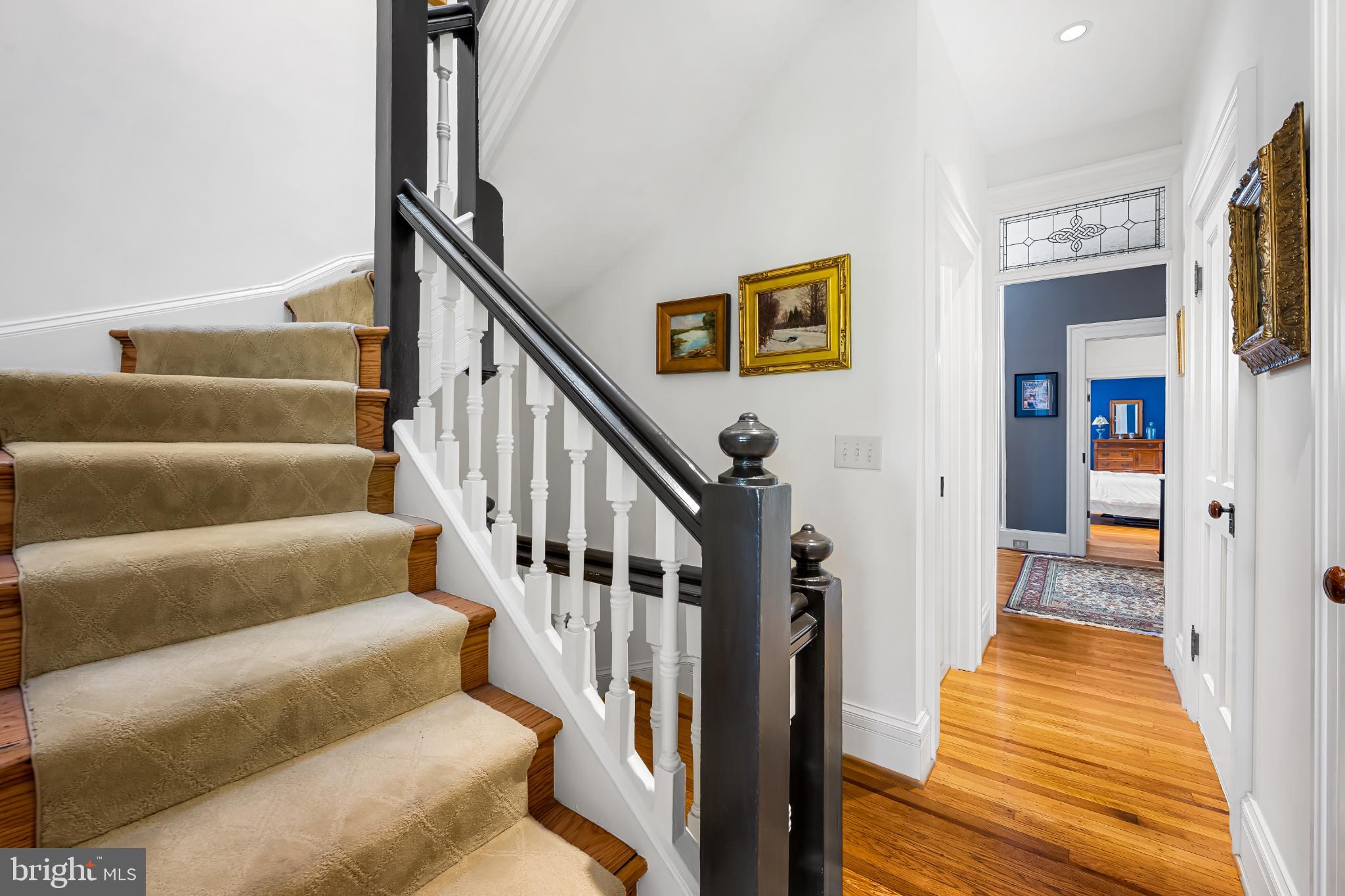 407 Warren Avenue Baltimore, MD 21230 - Photo 50 of 85 a view of staircase with lots of frames on wall and wooden floor