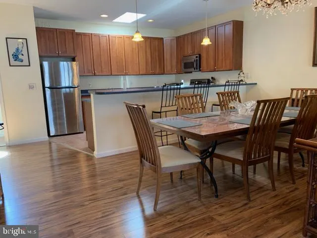 a kitchen with stainless steel appliances wooden floors wooden table and chairs