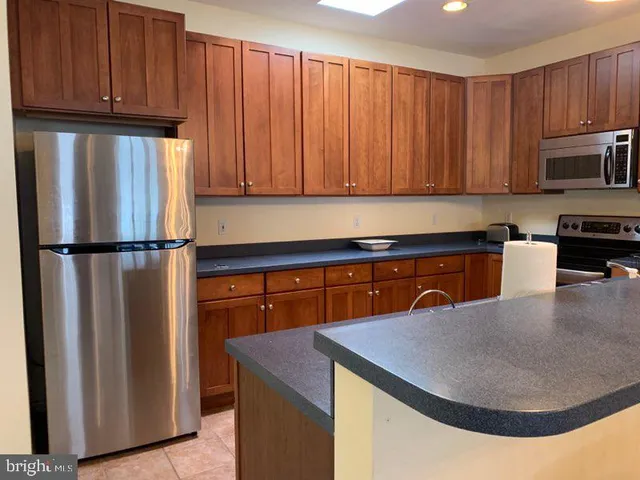 a kitchen with stainless steel appliances granite countertop a refrigerator a stove a sink and dishwasher