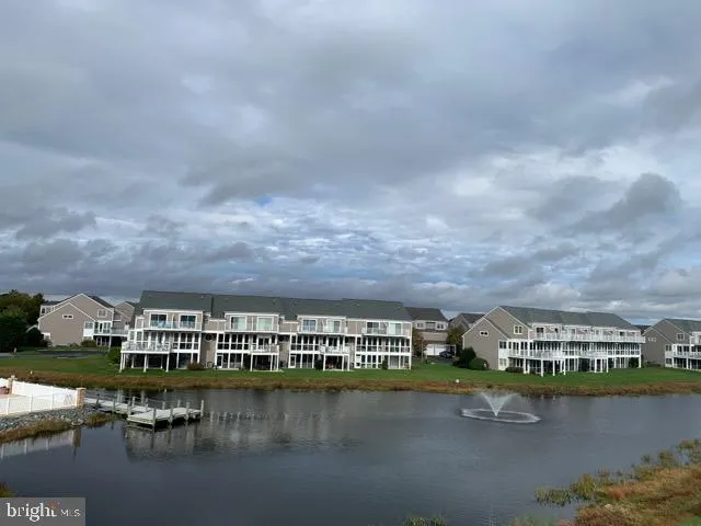 a view of house with yard and lake