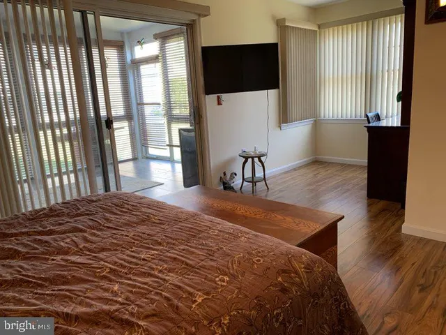 a bedroom with a bed tv and a large window