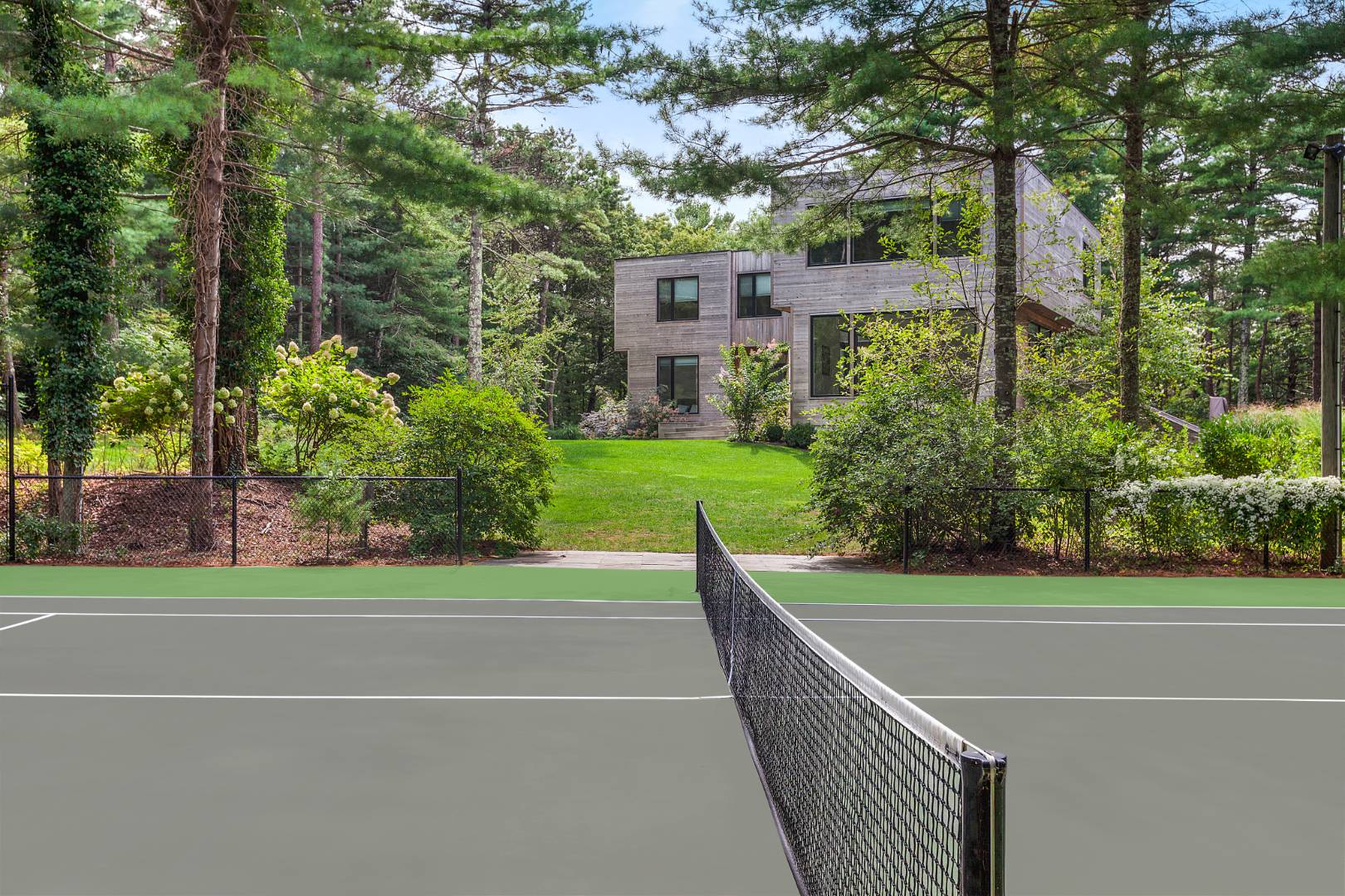 101 2 Holes Water Road East Hampton, NY 11937 - Photo 27 of 27 a view of a tennis court with a house in the background