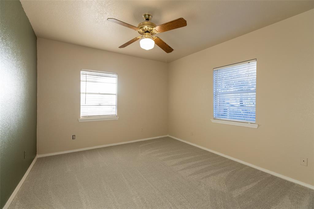 2401 West Bethesda Road Burleson, TX 76028 - Photo 5 of 12 an empty room with a window and a ceiling fan