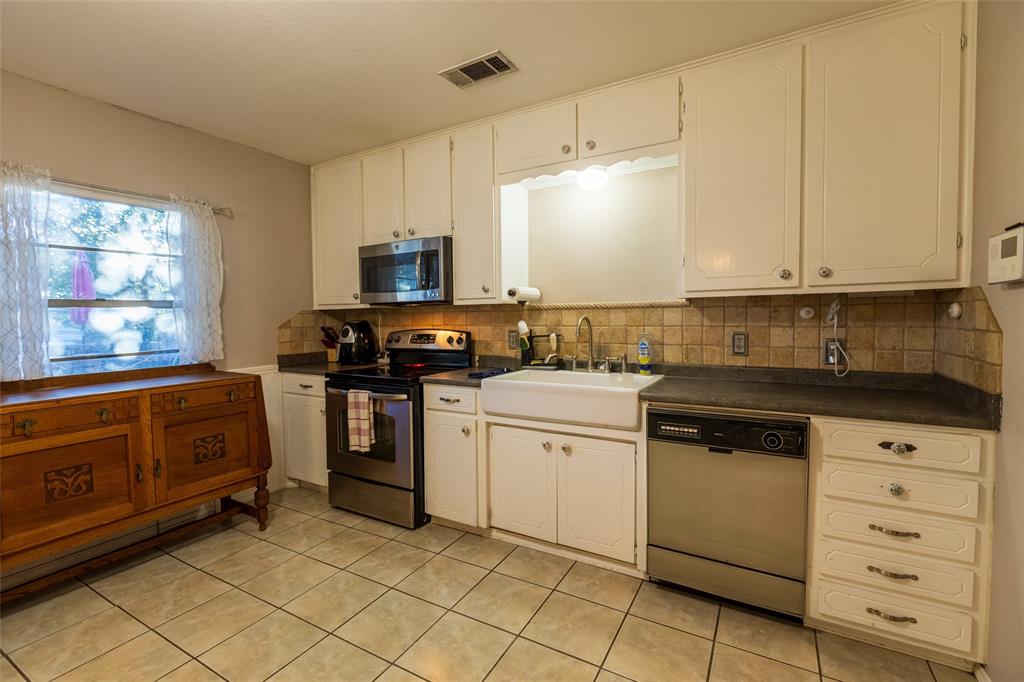 2401 West Bethesda Road Burleson, TX 76028 - Photo 7 of 12 a kitchen with granite countertop cabinets stainless steel appliances and a sink