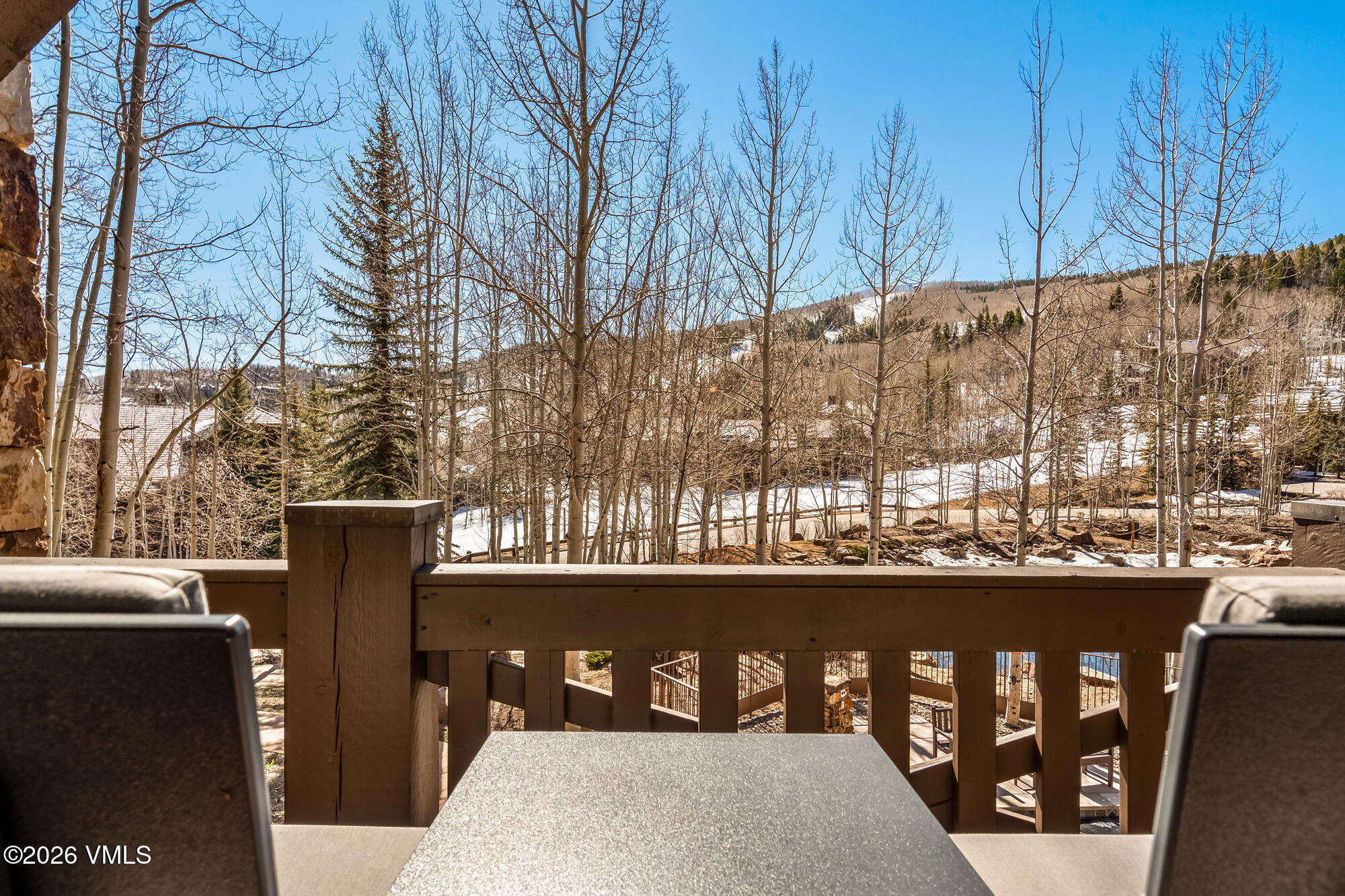 1087 Bachelor Ridge Road, Unit 205 Avon, CO 81620 - Photo 28 of 46 a view of a balcony with two chairs and a table