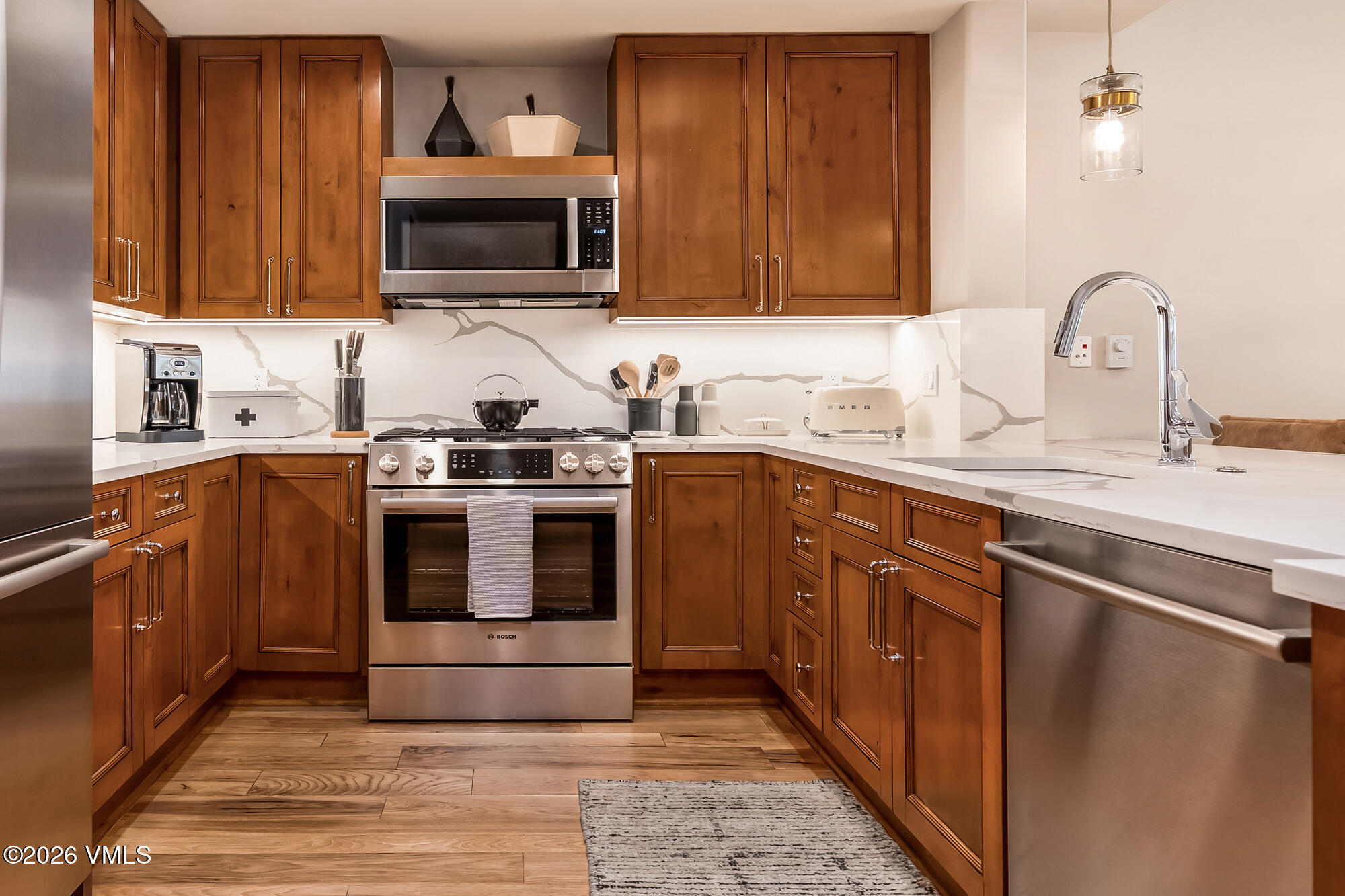 1087 Bachelor Ridge Road, Unit 205 Avon, CO 81620 - Photo 8 of 46 a kitchen with stainless steel appliances granite countertop a stove a sink dishwasher and a microwave oven with wooden cabinets