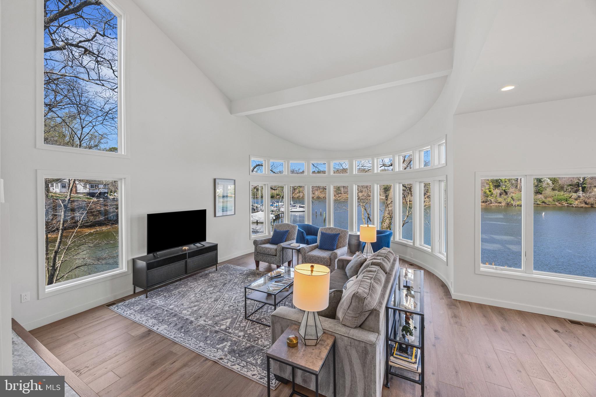 378 Forest Beach Road Annapolis, MD 21409 - Photo 7 of 42 a living room with furniture a flat screen tv and a floor to ceiling window