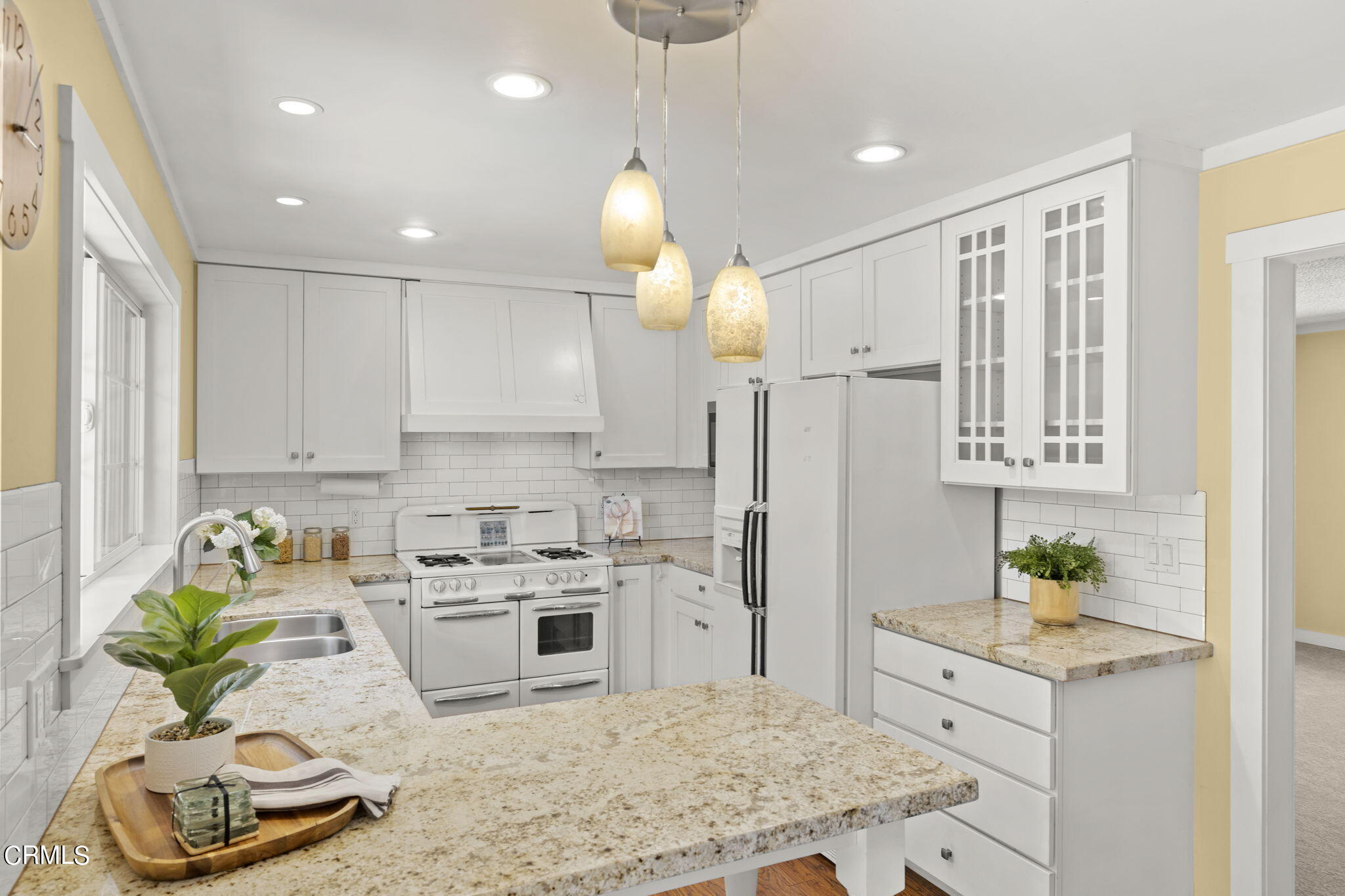 320 Cruzero Street Ojai, CA 93023 - Photo 16 of 48 a kitchen with stainless steel appliances granite countertop a sink a stove a refrigerator white cabinets and wooden floor