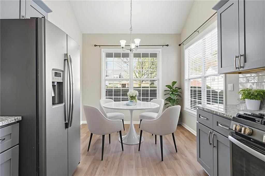 1527 Anna Ruby Lane Kennesaw, GA 30152 - Photo 12 of 42 a view of a dining room with furniture large windows and wooden floor