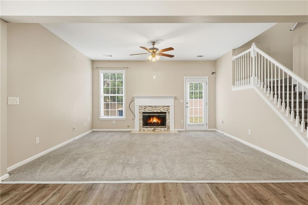 1527 Anna Ruby Lane Kennesaw, GA 30152 - Photo 19 of 42 a view of a livingroom with a fireplace a ceiling fan and windows