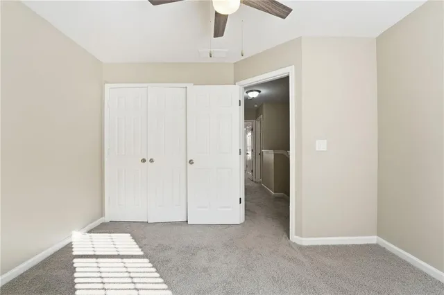 a view of a room with a ceiling fan and entryway