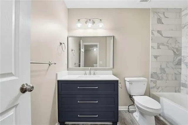 a bathroom with a toilet a sink and mirror