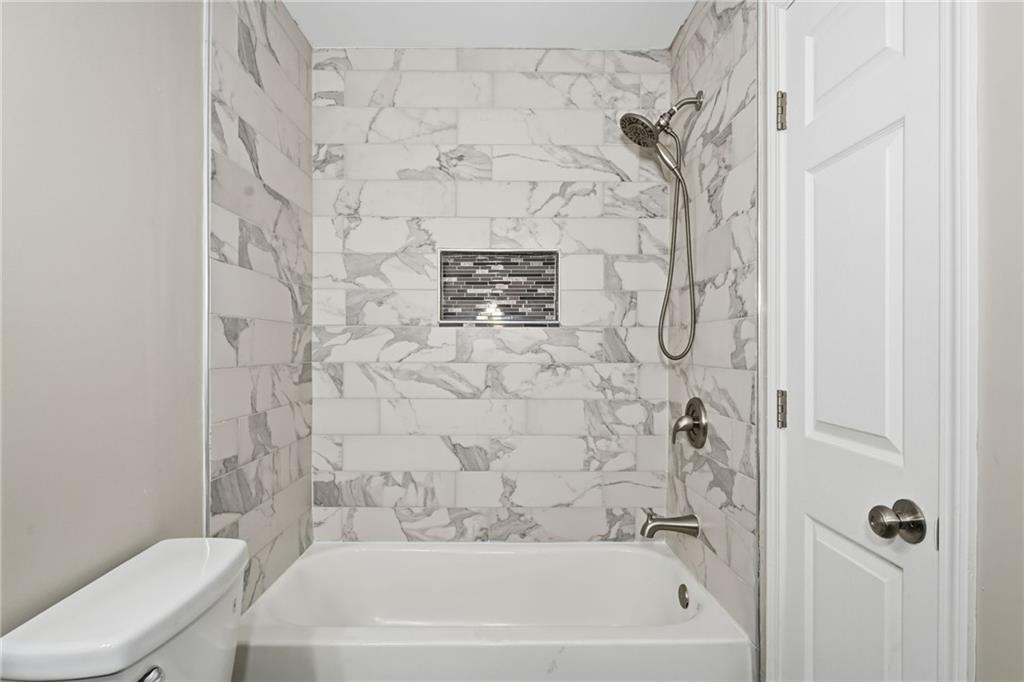 1527 Anna Ruby Lane Kennesaw, GA 30152 - Photo 31 of 42 a bathroom with a bathtub and a toilet
