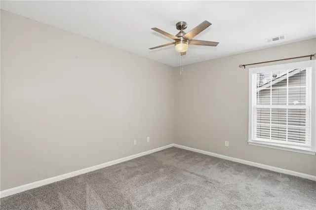 an empty room with a window and a fan