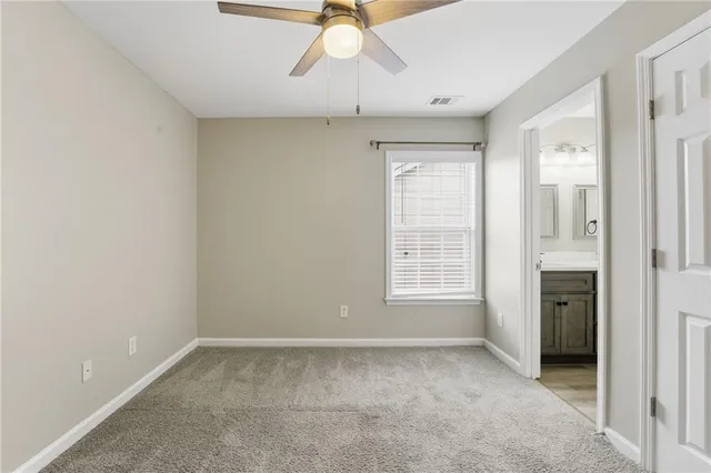 a view of an empty room with chandelier fan and fire place