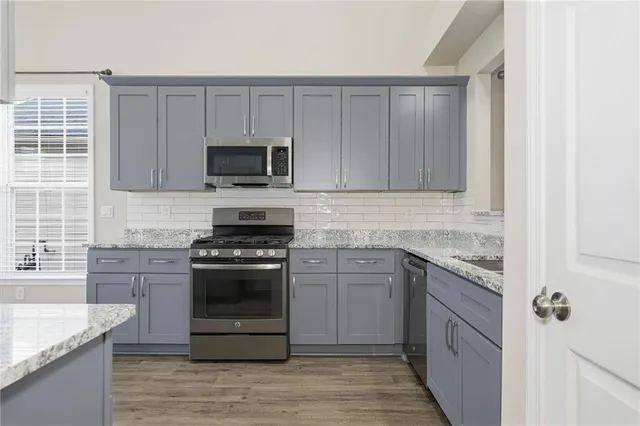 a kitchen with granite countertop a stove and a sink