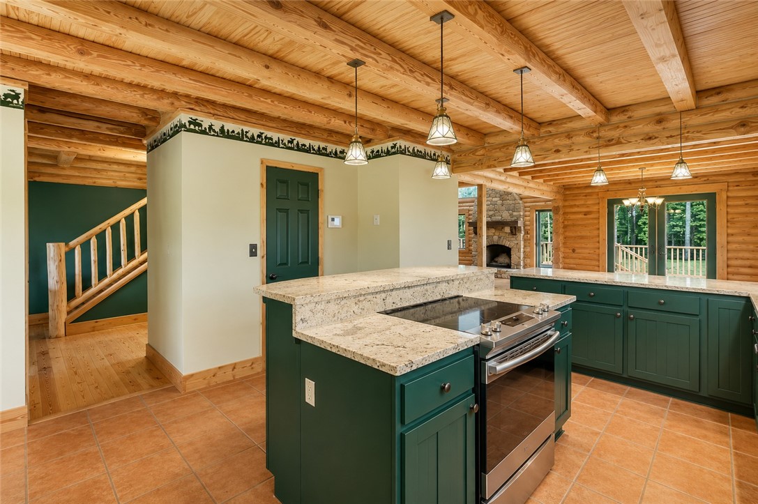 414 Devon Way Anderson, SC 29621 - Photo 11 of 50 A rustic-inspired kitchen features granite countertops, dark cabinetry, and exposed wooden beams overhead.