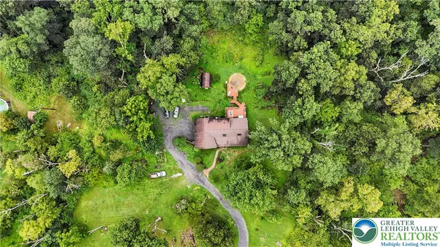 an aerial view of a houses with a lush green hillside